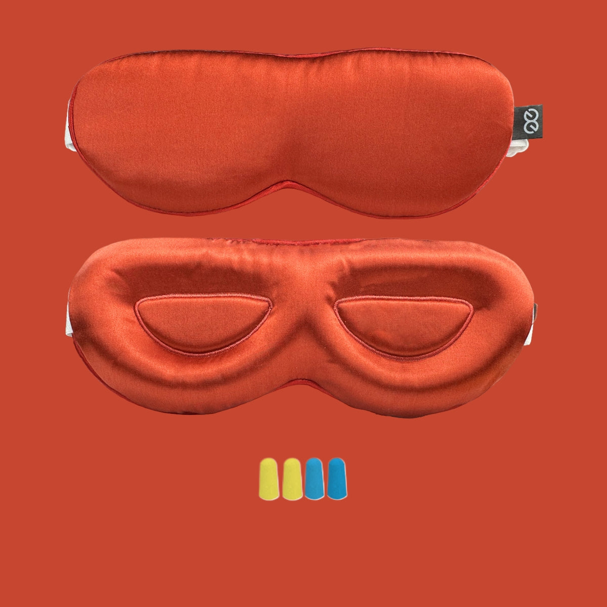 Two orange 23-momme mulberry silk 3D contour sleep masks on a plain studio backdrop, one flat and one with eye cutouts visible, with small c