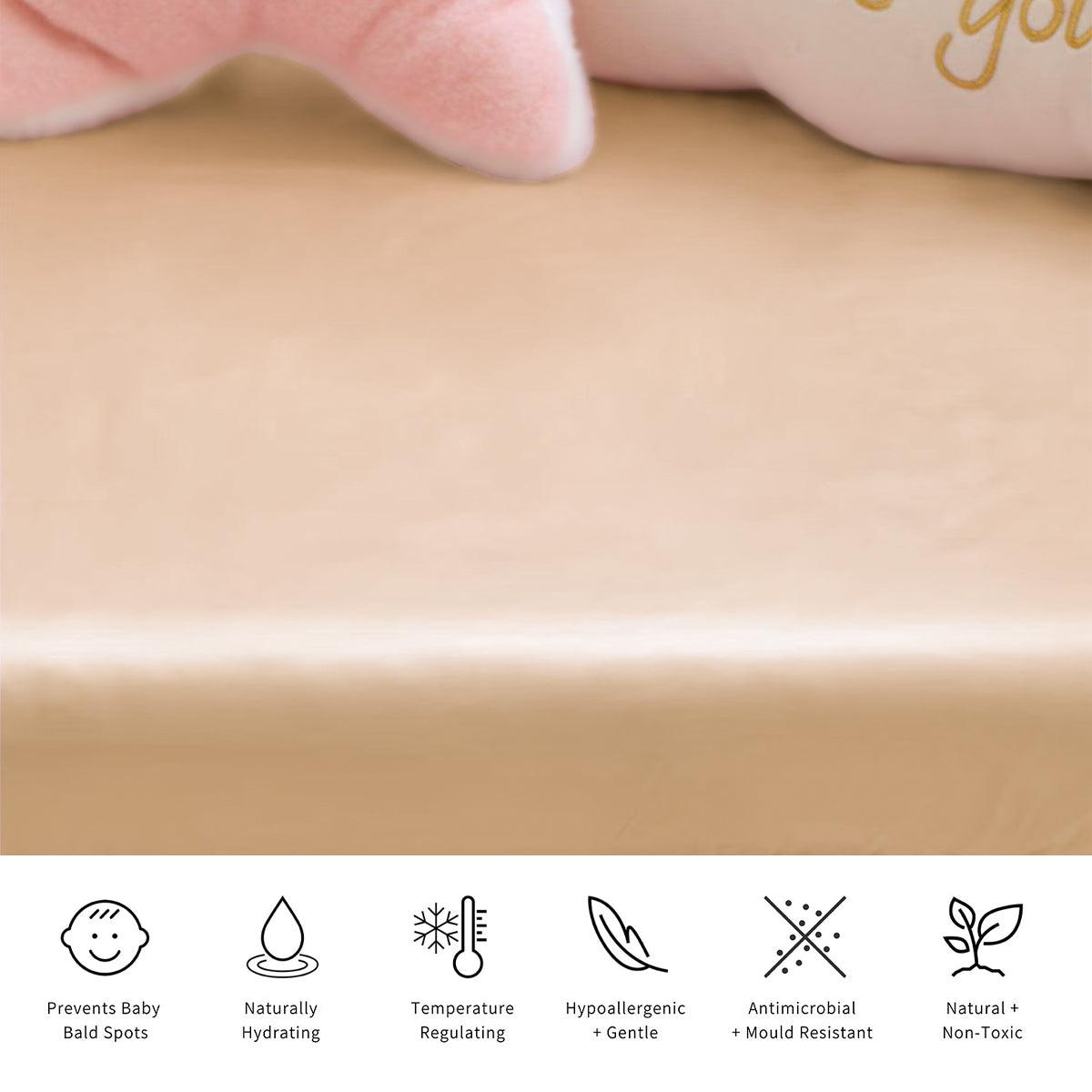 Fodera in seta beige per culla 23 momme su superficie piana con peluche rosa